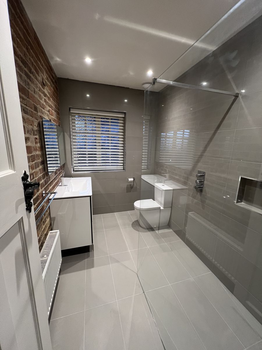 Bathroom with exposed brick vault ceiling by Optimum HVAC